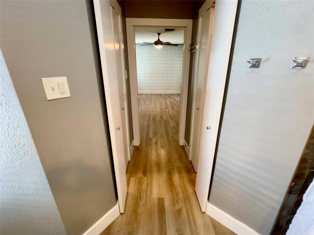 Walk-in closets on each side of the hallway between bedroom and bathroom.