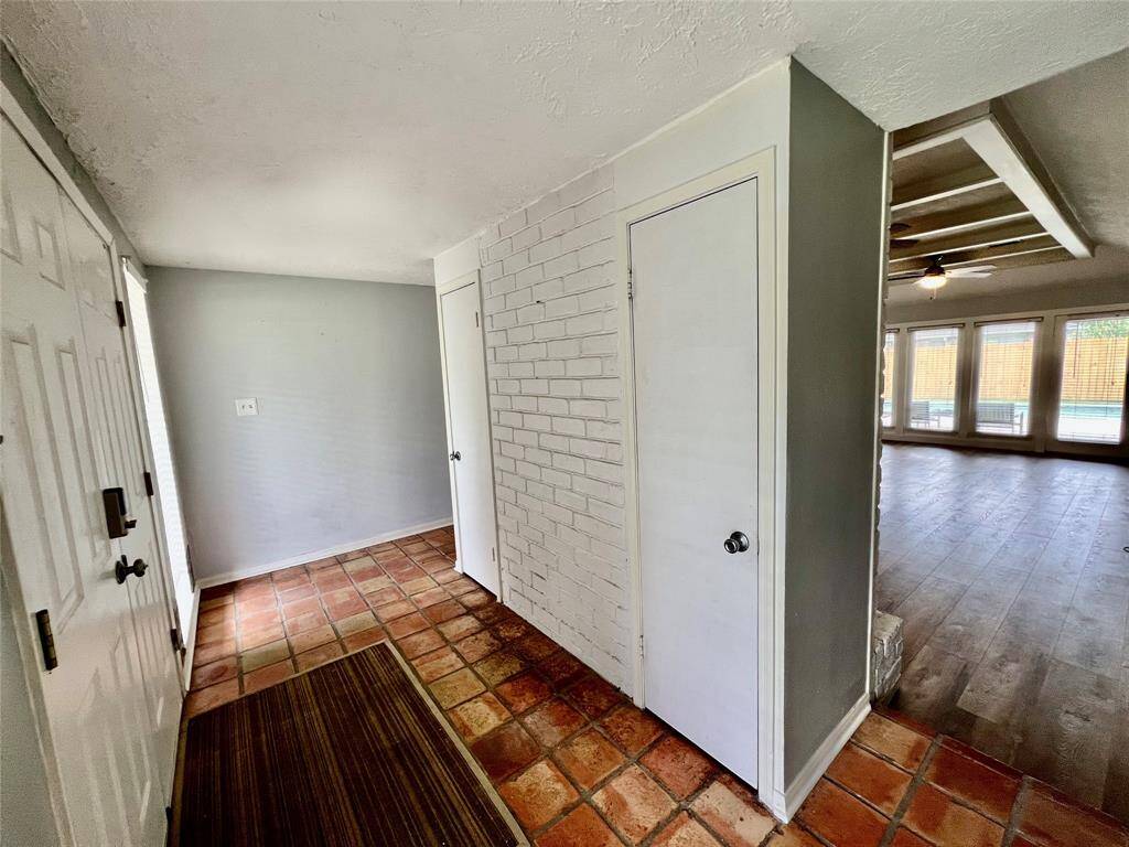 Entry tucked behind wood-burning fireplace. Handy storage closet on each side.