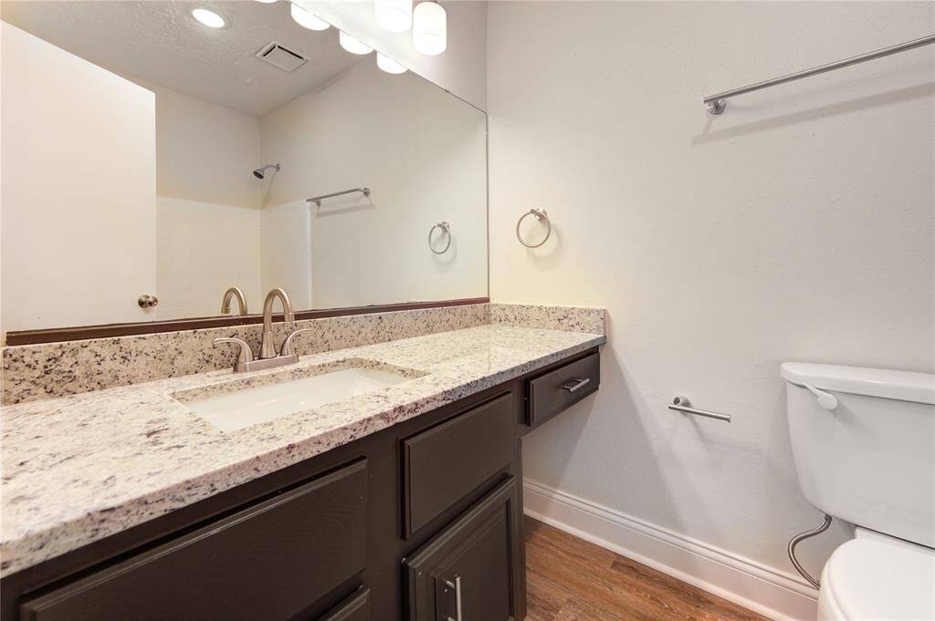 Secondary bath has new granite and undermount sink, new faucet, new hardware and light fixture.