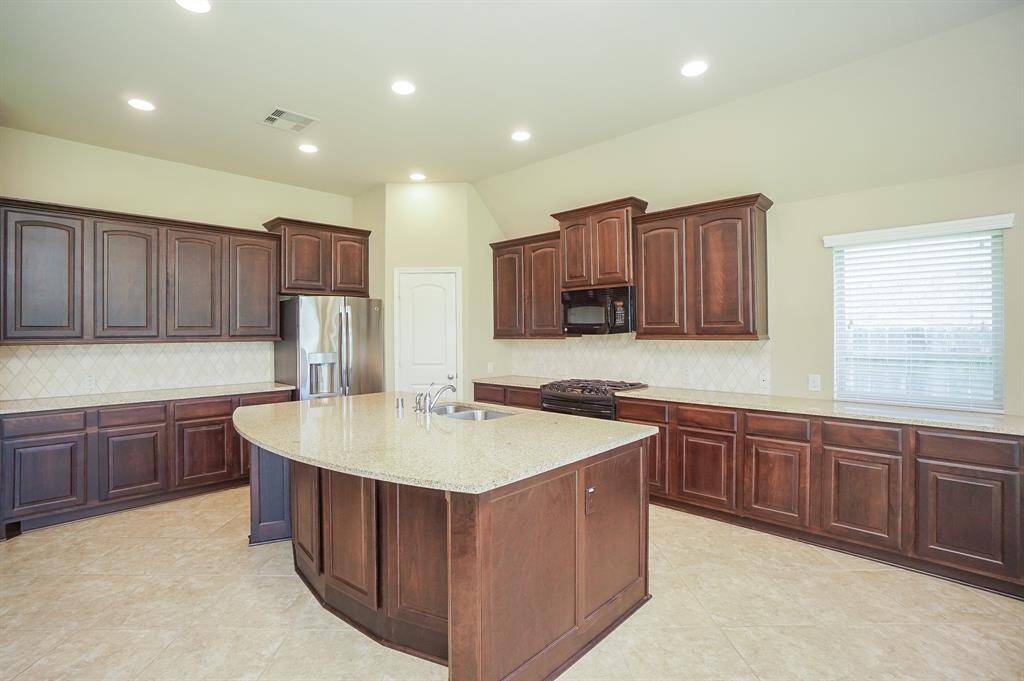 Pleasantly linear in appearance and use, the dual sink console is set into the huge granite topped island; with a cleverly curved edge to accommodate casual stools for quick snacks, and very handy when entertaining.