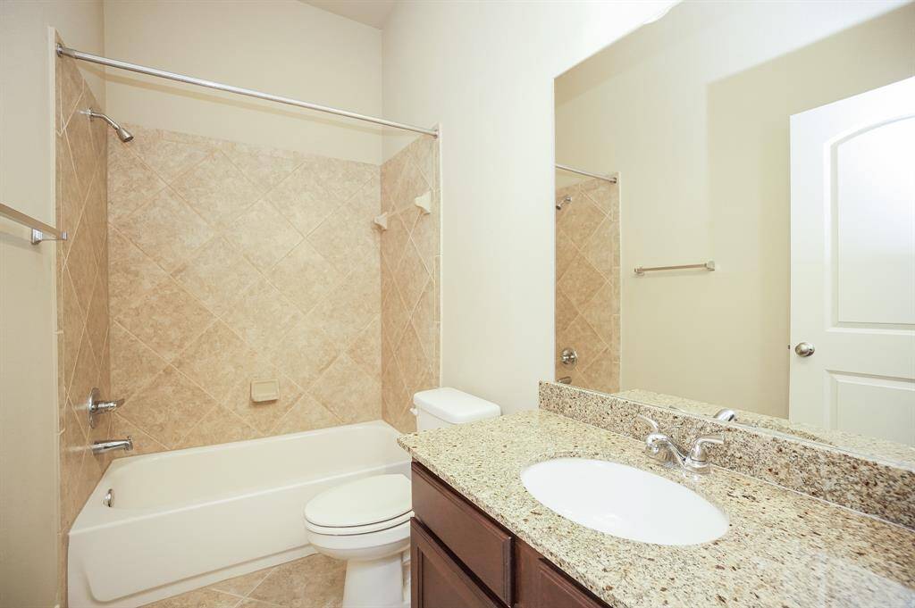 Subtle natural tones embrace granite countertop, rich cabinetry below and, combined shower/bathtub for easy options in the second bath.