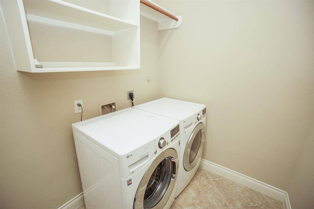 The utility room is spacious and easily accommodates dual appliances, with storage above.  Washer and Dryer included!