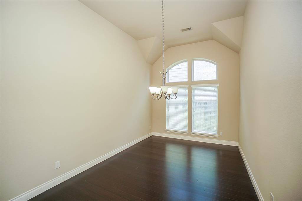 The home lists a variety of floor coverings, such as wood, engineered, wood, laminate, tile. This rich, shiny surface beautifully contrasts with pale tinted walls and a huge, arched, double window, in what can become a formal dining area.