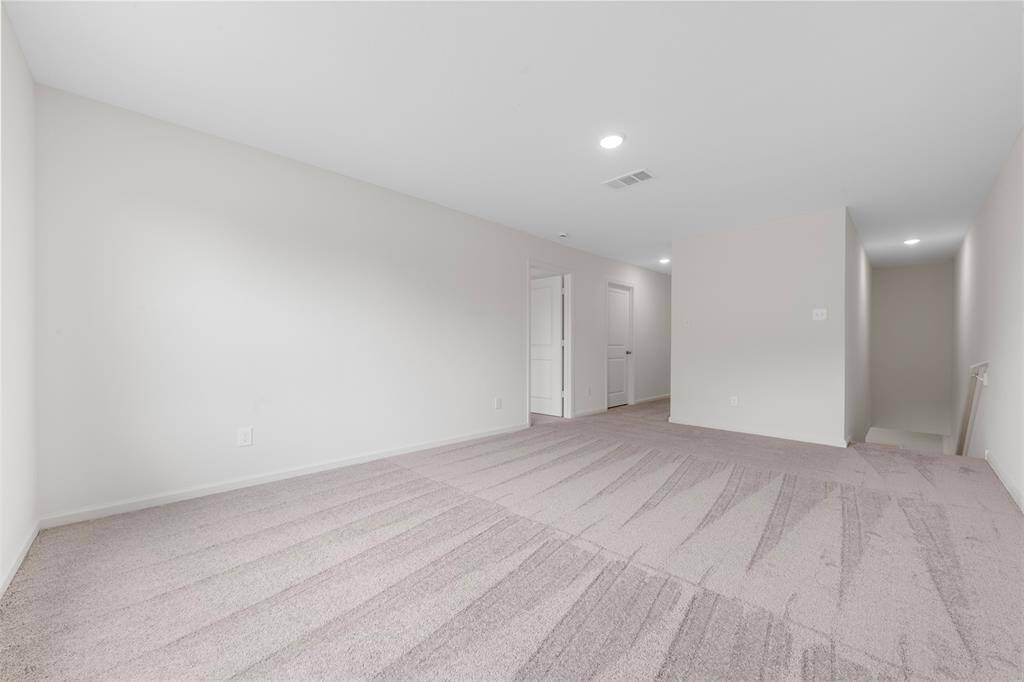 A spacious upstairs primary bedroom offering a luxurious en suite bathroom with dual vanities, a soaking tub, separate shower, and a generous walk-in closet.
