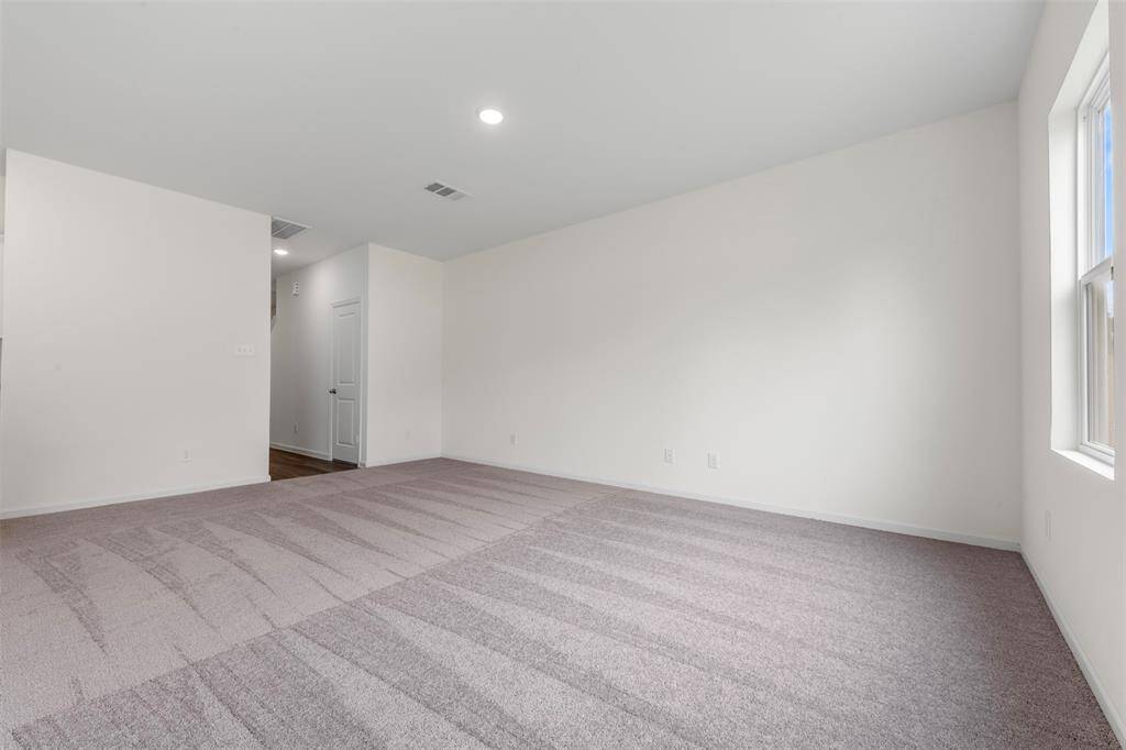 A spacious upstairs primary bedroom offering a luxurious en suite bathroom with dual vanities, a soaking tub, separate shower, and a generous walk-in closet.