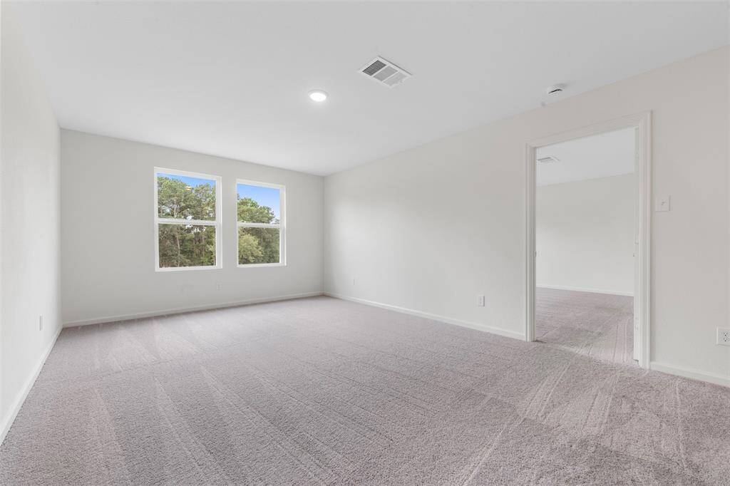 A spacious upstairs primary bedroom offering a luxurious en suite bathroom with dual vanities, a soaking tub, separate shower, and a generous walk-in closet.