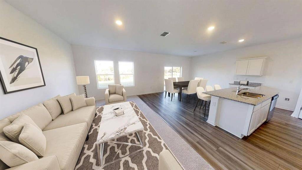 A brand-new two-story residence showcasing contemporary architecture with a welcoming front porch, manicured lawn, and a spacious two-car attached garage.