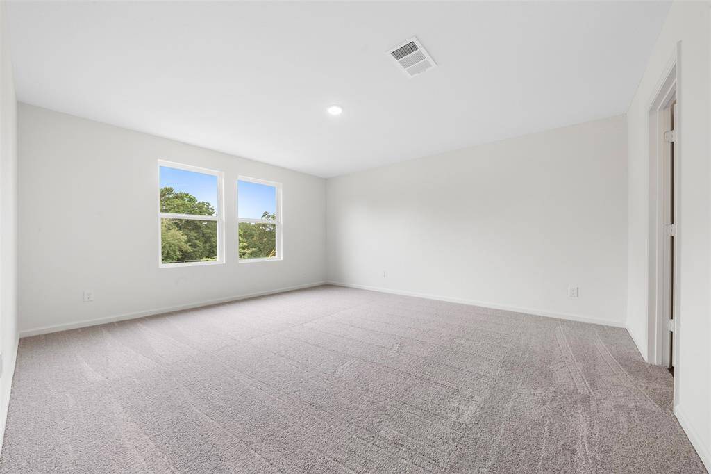 A spacious upstairs primary bedroom offering a luxurious en suite bathroom with dual vanities, a soaking tub, separate shower, and a generous walk-in closet.