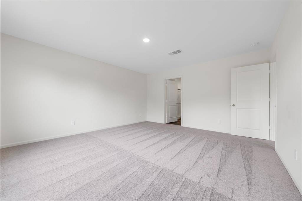 A spacious upstairs primary bedroom offering a luxurious en suite bathroom with dual vanities, a soaking tub, separate shower, and a generous walk-in closet.