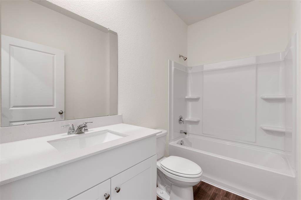 A conveniently located bedroom on the main floor, perfect for guests or multi-generational living, accompanied by a full bathroom featuring contemporary fixtures.
