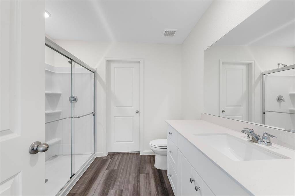 A conveniently located bedroom on the main floor, perfect for guests or multi-generational living, accompanied by a full bathroom featuring contemporary fixtures.