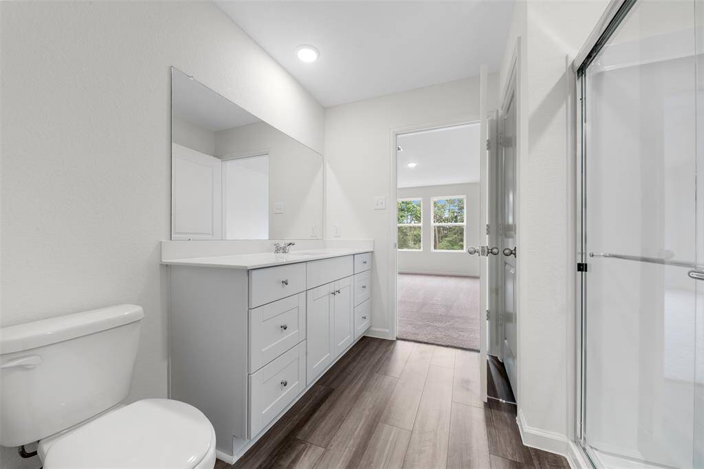 A conveniently located bedroom on the main floor, perfect for guests or multi-generational living, accompanied by a full bathroom featuring contemporary fixtures.