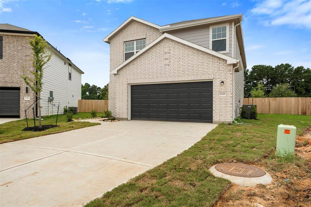 A brand-new two-story residence showcasing contemporary architecture with a welcoming front porch, manicured lawn, and a spacious two-car attached garage.