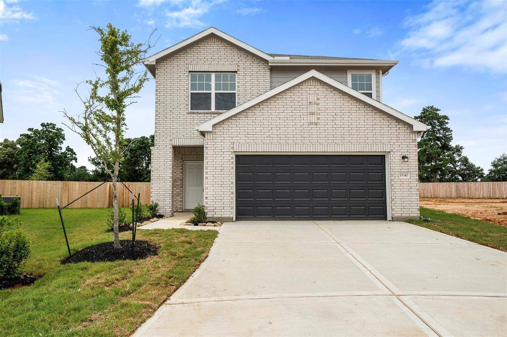 A brand-new two-story residence showcasing contemporary architecture with a welcoming front porch, manicured lawn, and a spacious two-car attached garage.