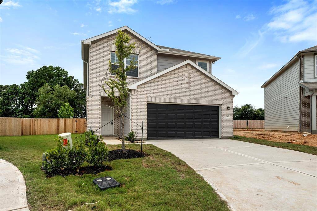 A brand-new two-story residence showcasing contemporary architecture with a welcoming front porch, manicured lawn, and a spacious two-car attached garage.