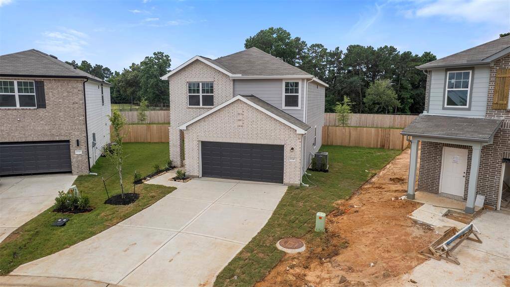 A brand-new two-story residence showcasing contemporary architecture with a welcoming front porch, manicured lawn, and a spacious two-car attached garage.