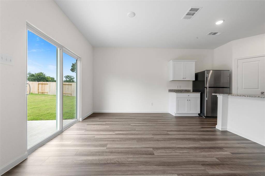 An open-concept living area featuring large windows that flood the space with natural light, neutral-toned walls, and modern flooring, creating a warm and inviting atmosphere.