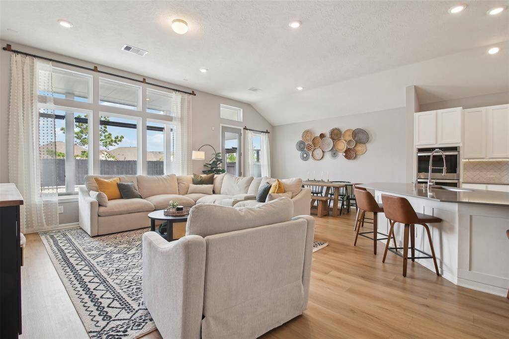 Bright and inviting, the spacious living room is the heart of the home. Large windows flood the space with natural light, highlighting the open-concept layout and neutral tones.