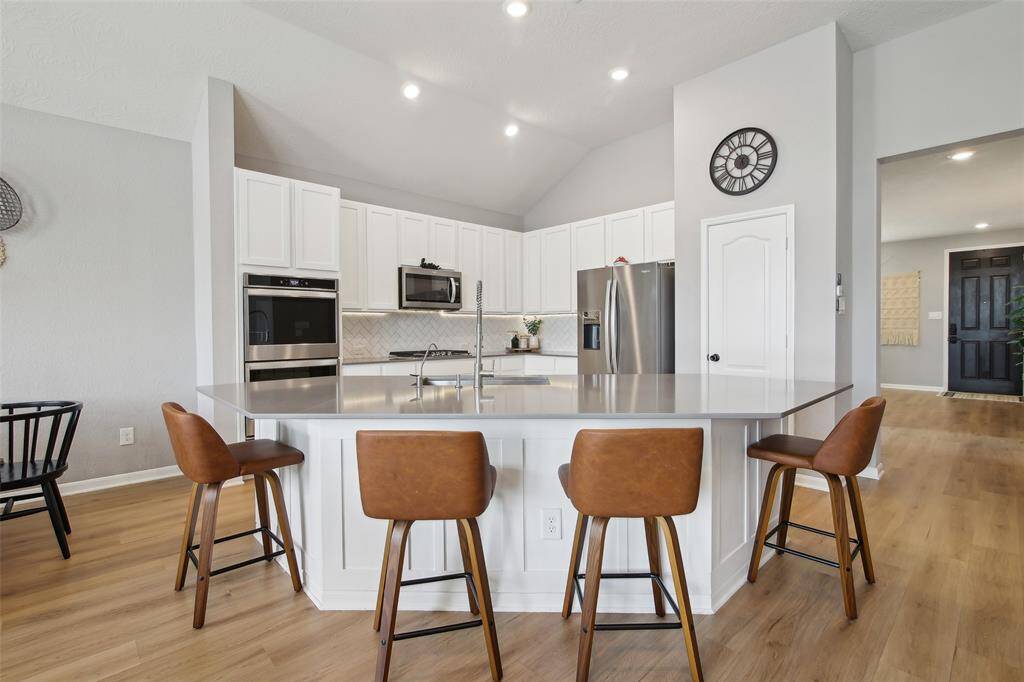 A true showstopper, the kitchen features granite countertops, stainless steel appliances, and a large center island with bar seating.