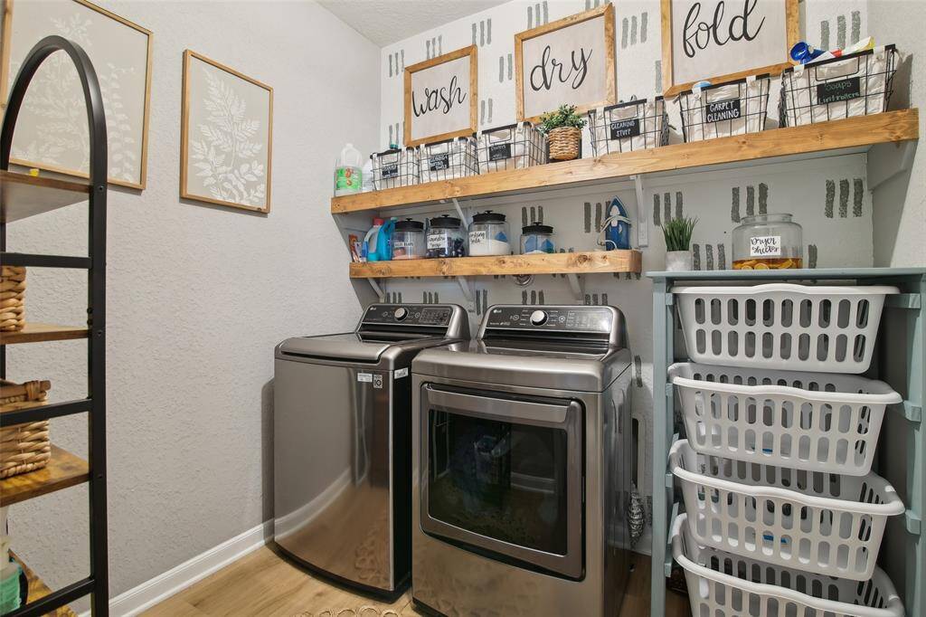 This stylish yet functional laundry room features built-in cabinetry, open shelving, and a spacious folding area—making everyday tasks feel effortlessly organized.