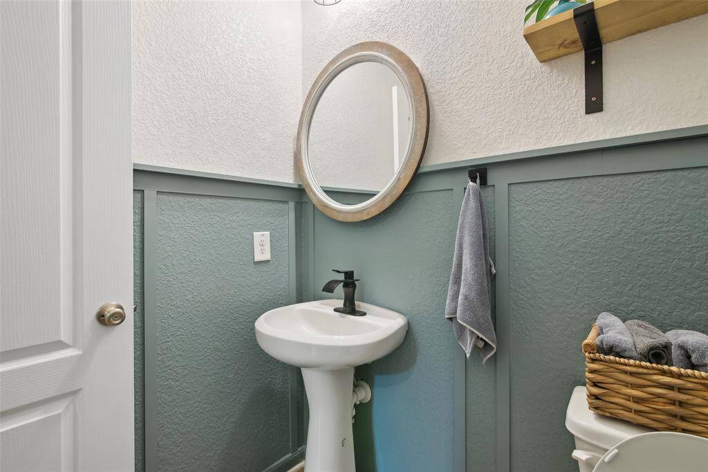 This elegant half bath has a sleek pedestal sink, designer lighting, and modern finishes—perfect for guests and everyday convenience.