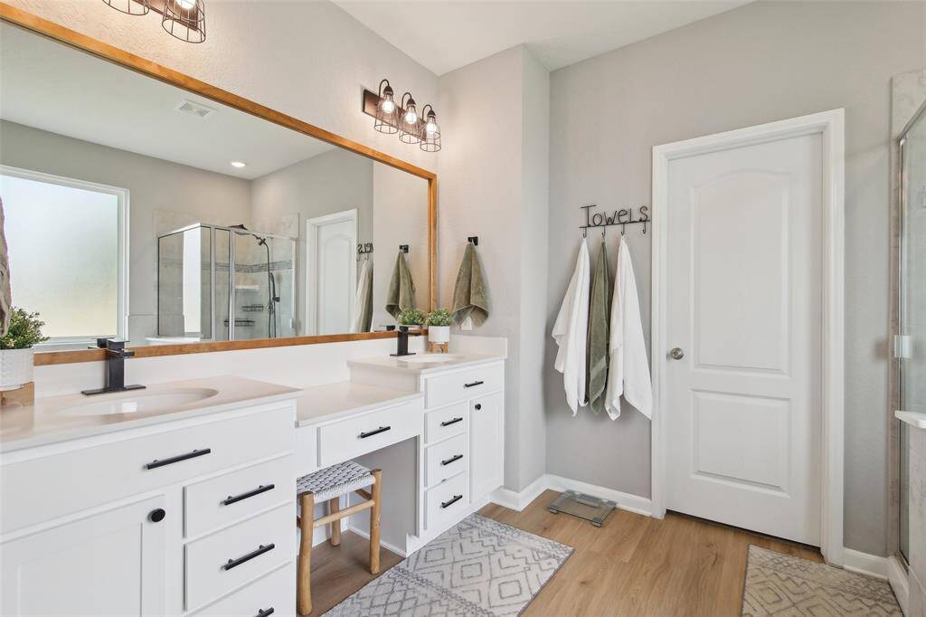 Double sinks with ample counter space provide convenience for busy mornings, while a private water closet adds extra privacy