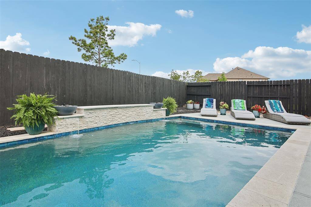 The backyard is a stunning retreat designed for both relaxation and entertaining.