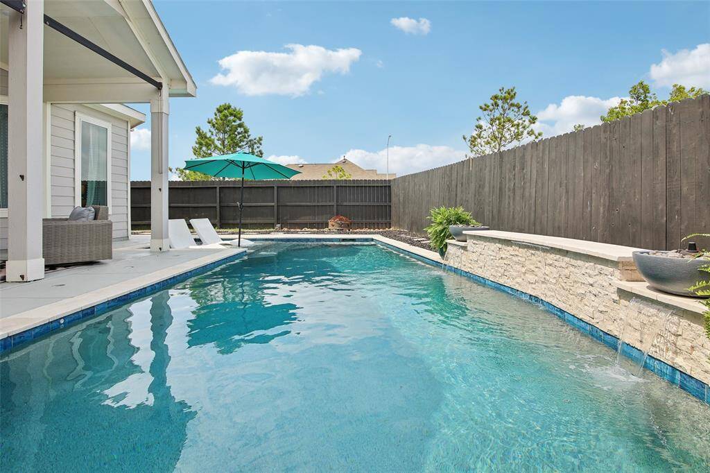 A graceful waterfall adds a soothing ambiance, creating a peaceful, spa-like atmosphere.
