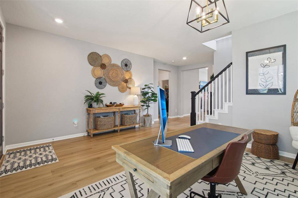 Light oak vinyl plank flooring flows seamlessly throughout the first floor, adding both elegance and durability to the open layout.
