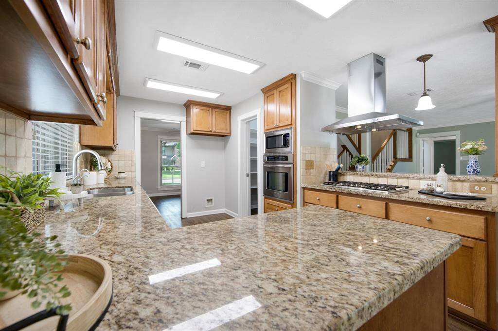 The kitchen is equipped with a 5-burner gas cooktop, ideal for home chefs and everyday cooking.
