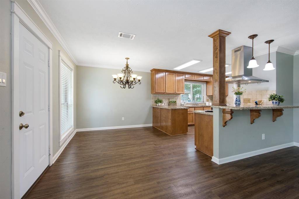 The breakfast nook space is conveniently located next to the kitchen and under a chandelier, adding an elegant touch to this cozy area.