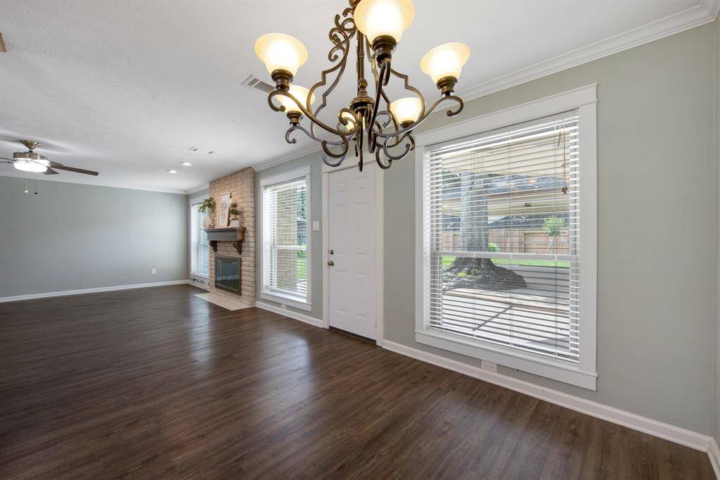 Rear-facing windows with blinds in the living room allow natural light to fill the space while maintaining privacy.