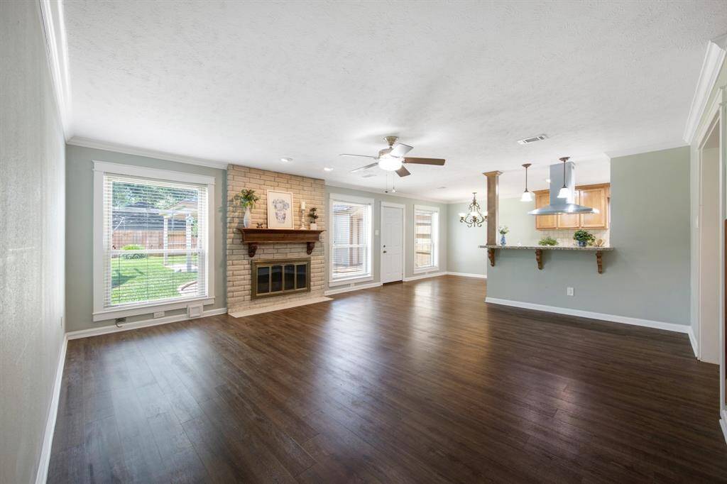 The living room features classic crown molding, a cozy fireplace, and a ceiling fan for added comfort.