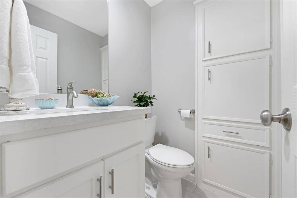 The half bath, located to the left of the living room, features a stylish granite countertop.This elegant detail adds a touch of sophistication to the convenient powder room.