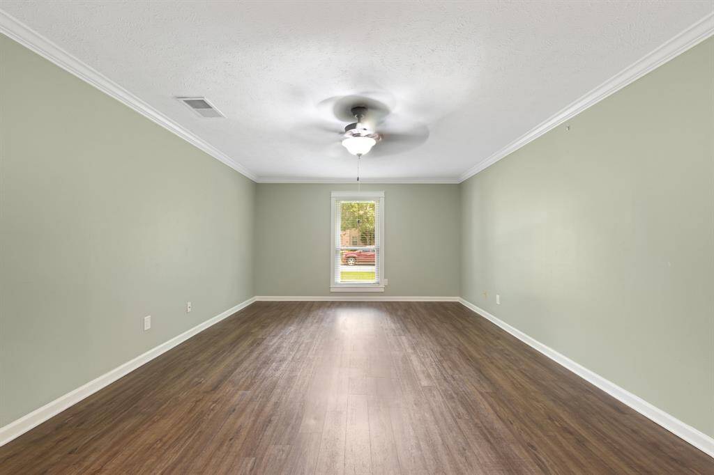 The primary bedroom features durable LVP flooring and elegant crown molding for a refined look.
