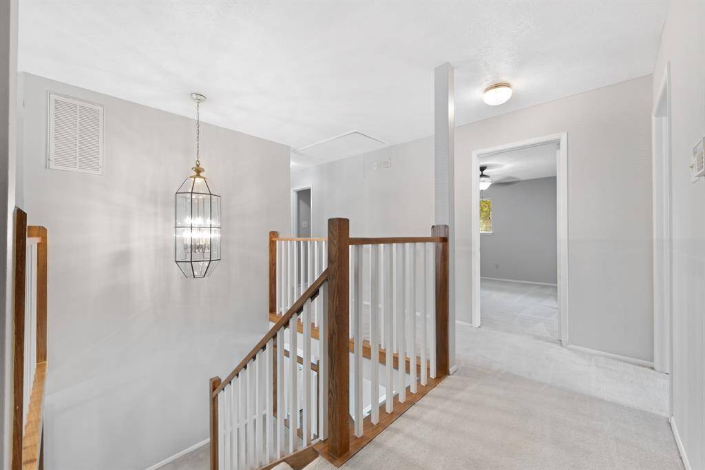 The stairs feature a stylish carpet and wood combination, blending comfort with classic design.