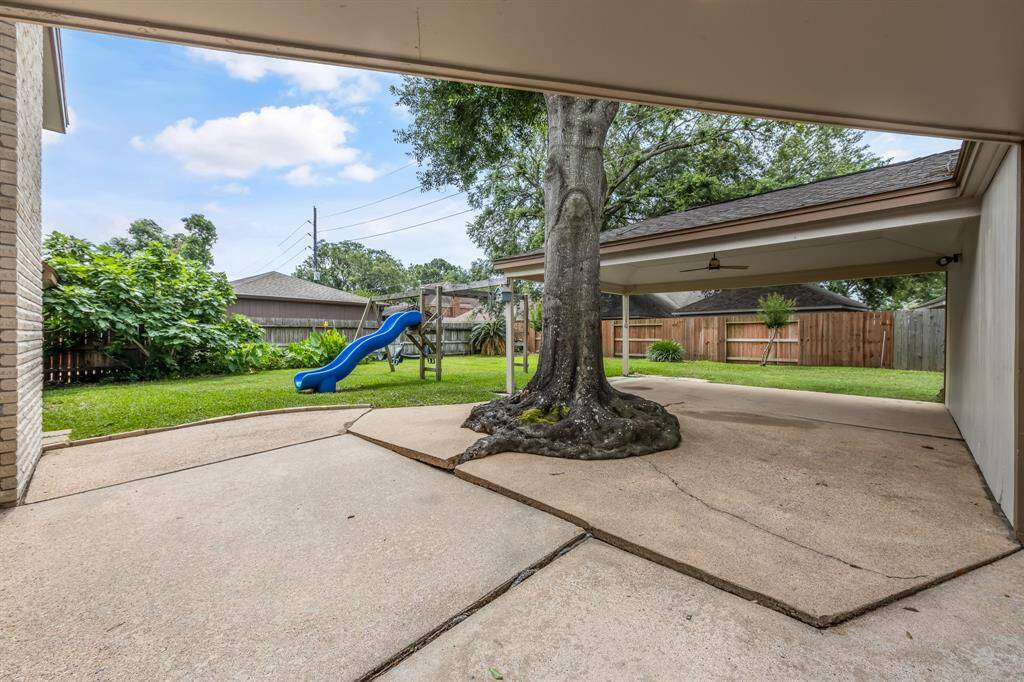 The backyard features a patio off the garage with a remote-controlled fan for outdoor comfort.
