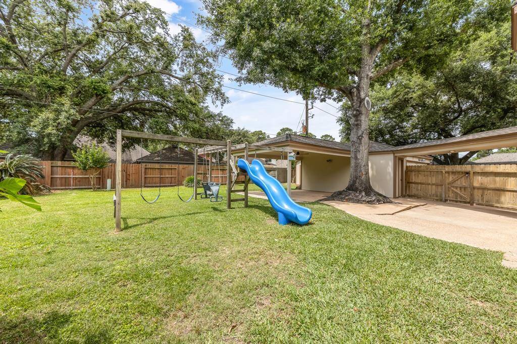 Additional highlights include a large shade fig tree with a play set for kids, adding charm and functionality to the space.