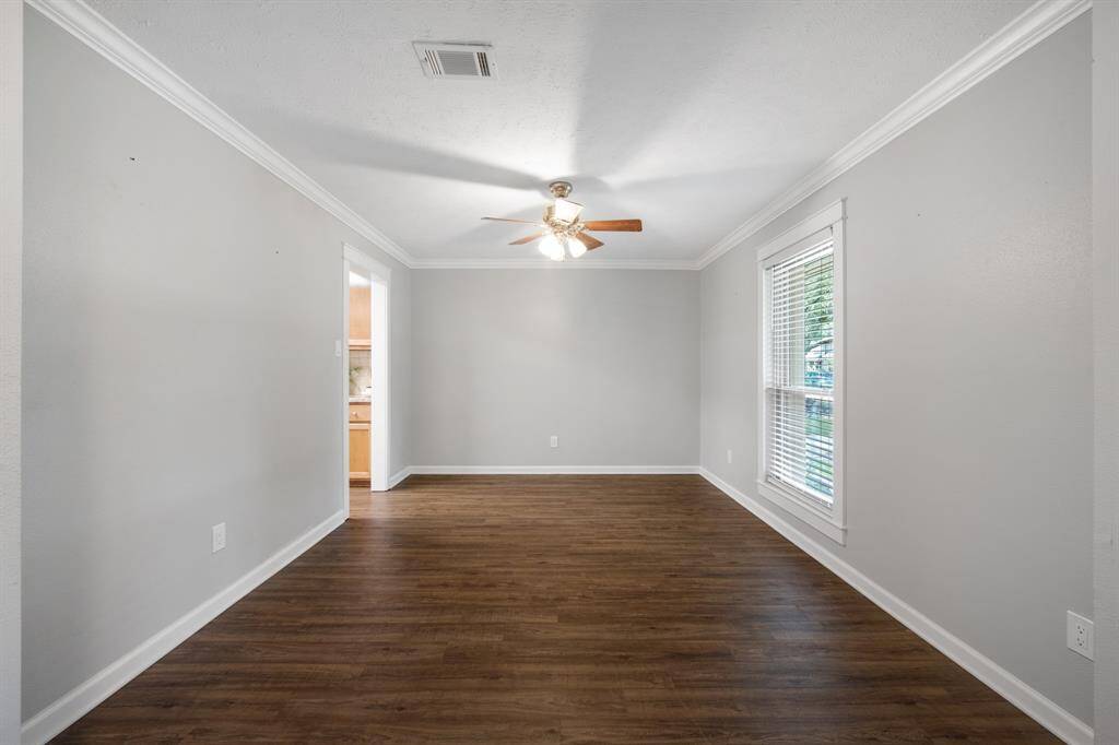 The formal dining room, located to the right of the entry, offers an elegant space for gatherings.Features include crown molding and a ceiling fan for added comfort and style.