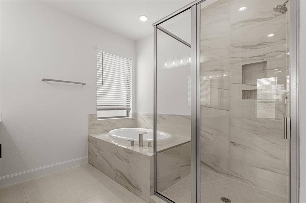 This incredible Primary Bathroom is complete with a garden tub with a privacy window, and beautiful glass enclosed shower.