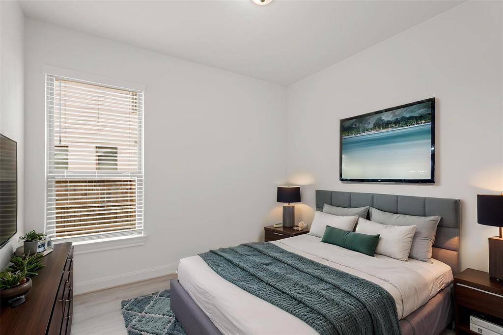 Virtually Staged: Secondary bedroom with LVP floors, and windows with privacy blinds.