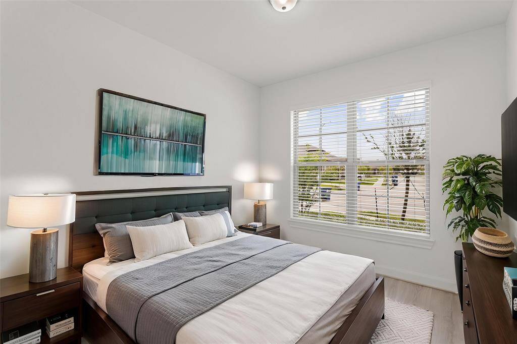 Virtually Staged: Secondary bedroom with LVP floors, and windows with privacy blinds.