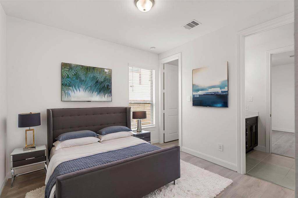 Virtually Staged: Secondary bedroom with LVP floors, a window with privacy blinds, a built-in closet, and access to a shared bathroom.
