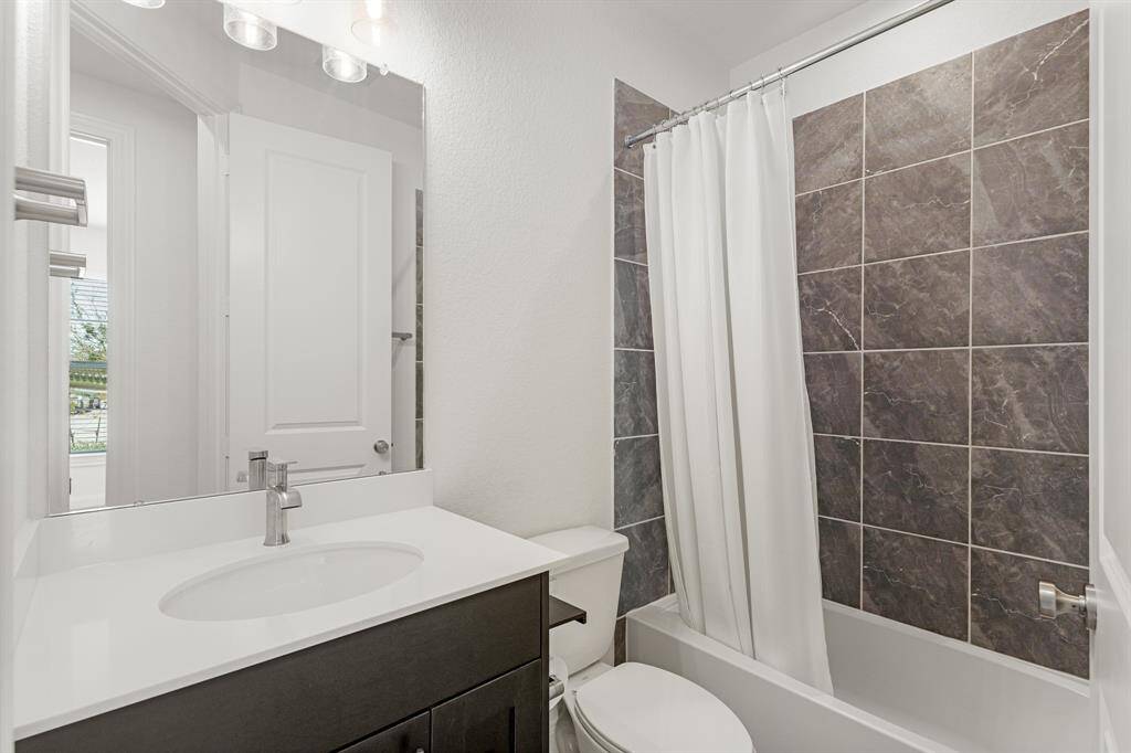 Secondary bathroom with granite counters, and a shower/tub combo.