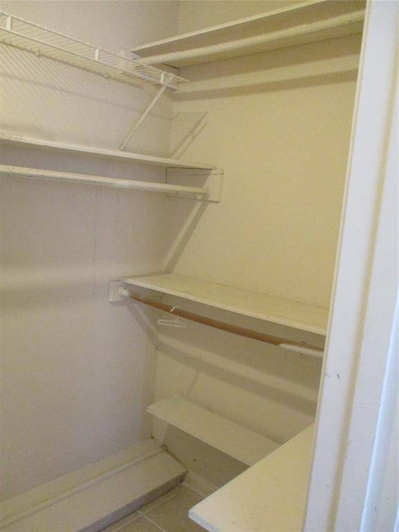 large walk in in primary bedroom with area for shoes on the floor