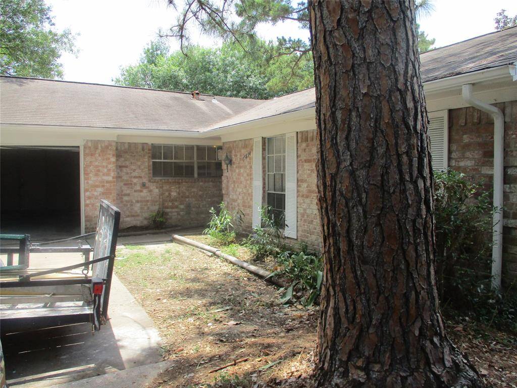 Covered entry and shade trees shade the driveway