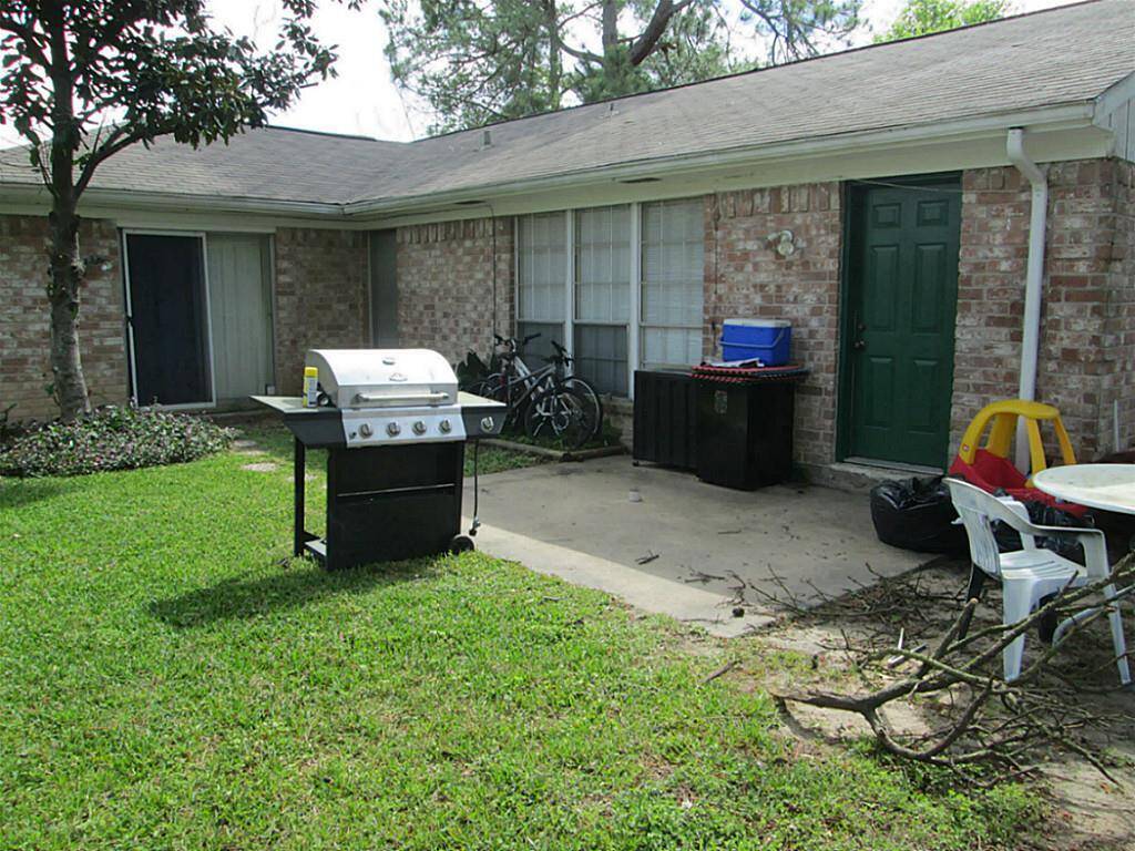 large patio in back yard with pine and magnolia trees.