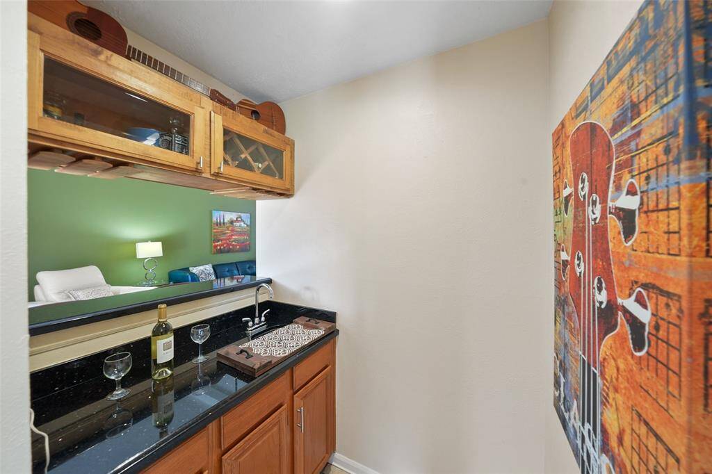 The family room boasts a vaulted ceiling, abundant natural light, elegant wood floors, and a marble gas fireplace.