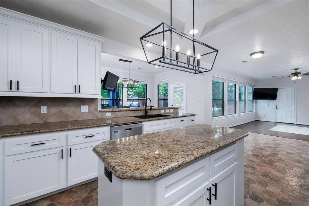 Custom light fixtures, natural light over the sink and open to the breakfast area and living area.