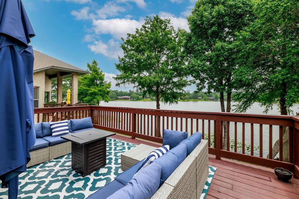 The open-air upstairs deck with a birds eye view of the trees and beautiful lake.
